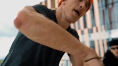 Hip hop takımı dans molası verirken, çok kültürlü bir arkadaş arkadaşını alkışlıyor ve alkışlıyor. Aktif ve enerjik sokak dansı. Açık hava sporu 2024 hiphop..