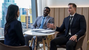 Şehir siluetine bakan süslü ofis, çeşitlilik uzmanlığı iddialı iş genişletme veya stratejik pazarlama tartışmaları. Finansal danışman, danışmanlık sektörü öngörüleri ve fikir verir