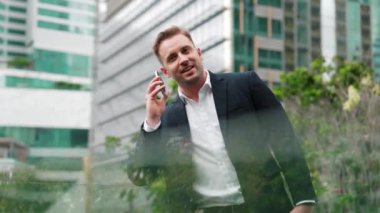 Başarılı bir iş adamı, pazarlama ekibiyle telefon kullanarak yatırım hakkında konuşurken çatıda duruyor. Kafkasyalı yatırımcı modern gökdelen manzarasına bakarak rahatlamanın keyfini çıkarıyor. Yaşam tarzı. Urbane
