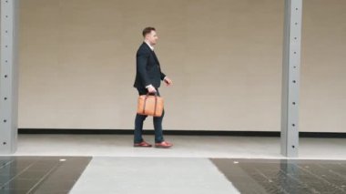 İş adamlarının bavul tutarken ve şehir merkezindeki iş yerine yürürken yan görüntüsü. Profesyonel proje yöneticisi dışarıda resmi takım elbise giyerken toplantıya gidiyor. Urbane.