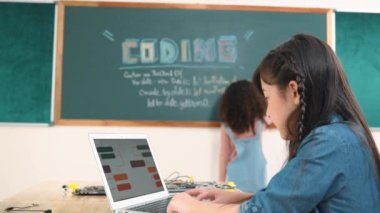 Kız, yazılım geliştirme planı yazarken yapay zeka yazılımı ya da programlama sistemini kullanarak kök sınıftaki elektronik ana tahtada yapay zeka üretiyor. Pedagoji.