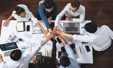 Üst düzey ofis çalışanları ofis odasında el ele tutuşarak iş sinerjisini ve iş yerindeki güçlü üretken takım çalışmasını sembolize ediyor. İş çalışanları arasındaki işbirliği ve birlik. Tedbirli