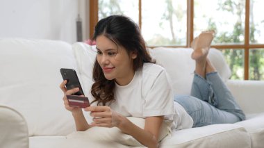 Kadın alışverişi ya da internet pazarında online ödeme modern yaşam tarzı için satılık eşyalar arıyor ve canlı siber güvenlik yazılımı tarafından korunan cüzdandan çevrimiçi ödeme için kredi kartı kullanıyor