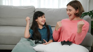 Mutlu çocuk oyun oynuyor ve oturma odasında otururken annesini kazanıyor. Çekici kız elini havaya kaldırıp şarapları kutlarken beyaz bir anneyle vakit geçiriyor. Pedagoji.