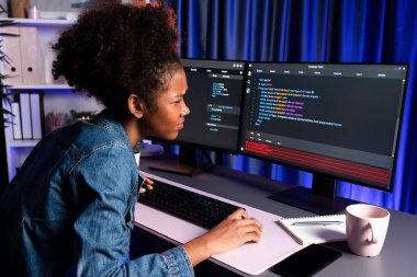 Kot pantolon giyen, siber kod kullanan, dizüstü bilgisayara konsantre olan, uygulama ve web sitesi verilerini gösteren, yenilikçi güncellenmiş bir sürüm yaratan genç Afrikalı bilişim uzmanı. Tatlandırıcı.
