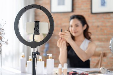 Kadın Etkilenen Vlog video görüntülerini canlı olarak çekiyor. Makyajın çoğu sosyal medya ya da blog 'u anlatıyor. Kozmetik stüdyosu ışıklandırmalı mutlu genç kız çevrimiçi pazarlama oturumu yayını için..
