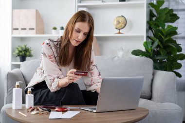Genç mutlu kadın internetten alışveriş yaparak ürün satın alırken aynı zamanda internet üzerinden online ödeme sistemi ile çevrimiçi mağaza platformundan en yüksek siber güvenlik tarafından korunan ürünler sipariş ediyor.