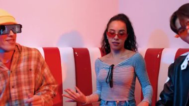 Mutlu kız kameraya bakıyor ve kanepede otururken pop müzik dinliyor. İspanyol kadın serbest stil dans ederken kameraya bakıyor neon ışıkta çeşitli arkadaşlarla dans ediyor. Mutluluk.