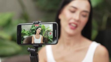 Arka plan görüntüsü ya da kamera arkasındaki kadın doğal güzelliği ve doğal bahçe video içeriği üzerine kozmetik dersi veriyor. Güzellik blogcusu sosyal medyum izleyicilere güzellik bakımını gösteriyor. Blithe