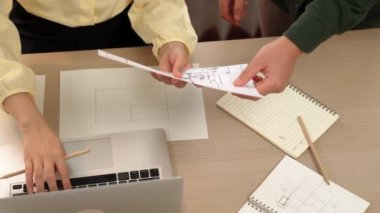 Akıllı mimar ve akıllı mühendisin dizüstü bilgisayarlı videosu mimarlık bürosundaki inşaat isabet planı hakkında tartışıyorlar. Eline odaklan. - Yakın çekim. Tanımlama.