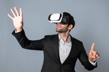 VR gözlük ve takım elbise giyerken veri analizine bakan yetenekli bir iş adamı. Proje yöneticisi görsel gerçeklik gözlüğü ya da kulaklık kullanırken kontrol ediyor ve seçiyor. Yenilik teknolojisi. Sapma.