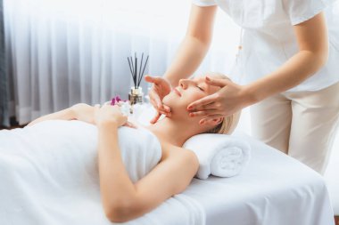 Kafkasyalı kadın stres önleyici kafa masajından ve lüks tatil beldesi ya da otel spa salonundaki modern ışık ortamında yüz güzelliği eğlencelerini şımartmaktan hoşlanıyor. Sessiz.