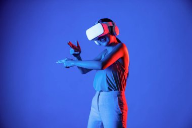 VR kulaklık takan zeki bir kadın metaevrene bağlanıyor, gelecekteki siber uzay topluluğu teknolojisi. Sanal silaha hükmeden zarif bir kadın ciddi ciddi oyun oynuyor. Halüsinasyon.