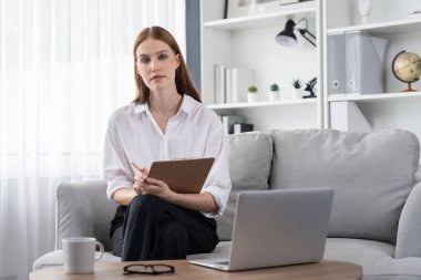 Klinikteki psikolog kadın. Profesyonel portresi. Dostane gülümsemesiyle hastayı psikoloğa davet ediyor. Tecrübeli ve kendine güvenen psikolog son derece uzmandır.