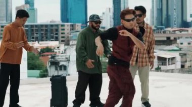 Çatıda çok kültürlü arkadaşlar varken profesyonel İspanyol break dansçısı B boy dansı. Genç modern dans grubu hip hop hareketi yapıyor. Tarz, moda, aksiyon. Açık hava sporu 2024 hiphop..