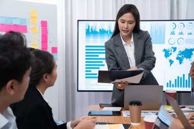 Genç Asyalı iş kadını modern toplantıda TV ekranında veri analizi paneli sunuyor. Bir grup iş adamıyla konferans odasında iş sunumu. Uyum