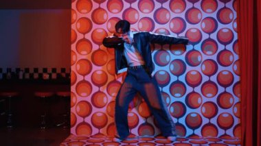 Asyalı break dansçı serbest stile geçiyor ve balon arka planlı kameraya bakıyor. Profesyonel hippi gündelik kıyafet giyer ve gözlük takar. Mutluluk.