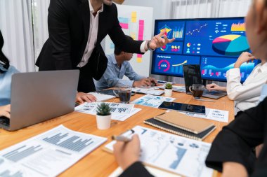 Finansal veri raporunu analiz eden çeşitli bir grup iş analisti. Mali veri analiz çizelgesi ve grafik paneli stratejik pazarlama planlama için toplantı odasında TV ekranında. Habiliment