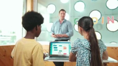 Kameraya bakmak için arkanızı dönerken çeşitli öğrenci programlama sistemleri. BTMM Teknoloji sınıfında çok kültürlü bir öğrenciye kodlama dersi veren beyaz bir öğretmen. Öğretim