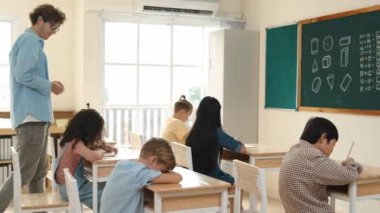 Öğrenci ödevlerine bakarken sınıfta yürüyen yetenekli bir öğretmen. Sınav yaparken ya da sınıfta ödev yaparken akıllı çocuk defterini kontrol eden profesyonel bir eğitmen. Pedagoji.