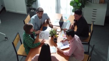Proje yöneticisinin üst görünümü toplantıda yatırımcılara mali grafik sunuyor. Profesyonel pazarlama ekibi dizüstü bilgisayardan finansal istatistiklere bakarken finansal fikir üretiyor. Cemaat.