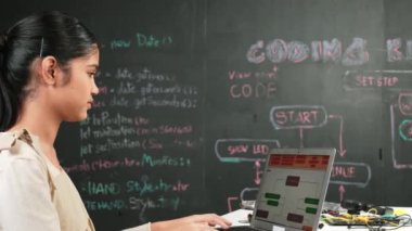 Liseli kız BTMM Teknoloji dersine katılırken hemen kod ya da mühendislik dersi alıyor. Tahtanın önündeki bilgisayar ekranına bakarken ergen kodlaması ya da programlama sistemi. Öğretim