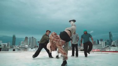 İspanyol hipster dansları şehrin mavi gökyüzü manzaralı çok kültürlü arkadaşlarıyla çevrili. Çatıda bir grup sokak dansçısı sahne alıyor. Aktif, eğlenceli, mutlu atmosfer. Açık hava sporu 2024 hiphop..