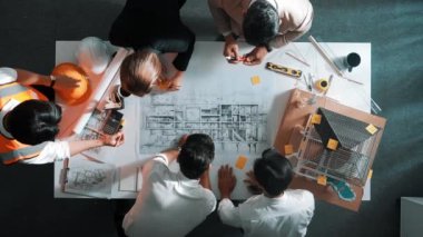 Becerikli mühendis ekibinin ev inşaatından bahsedişinin en alt görüntüsü. Mimar ya da tasarımcı grubunun planlar hakkında beyin fırtınası yapmak için tartışan ve yazan hava görüşü. Hizalama.