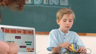 Kafkas akıllı çocuk kök teknoloji dersinde tornavida kullanarak ana tahtayı tamir ederken aynı zamanda gülümseyen öğrenci de dizüstü bilgisayar ekranı kodlu elektronik makineyi incelemek için birlikte çalışıyor. Pedagoji.
