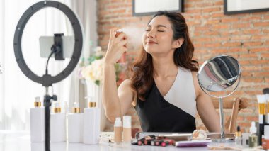 Kadın Etkilenen Vlog video görüntülerini canlı olarak çekiyor. Makyajın çoğu sosyal medya ya da blog 'u anlatıyor. Kozmetik stüdyosu ışıklandırmalı mutlu genç kız çevrimiçi pazarlama oturumu yayını için..