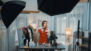 Kadın nüfuzlu kişi video görüntülerini canlı yayınlıyor. Kıyafetler sosyal medyada ya da blogda yer alıyor. Stüdyo ışıklandırmalı mutlu genç kız çevrimiçi pazarlama oturumu yayını için..