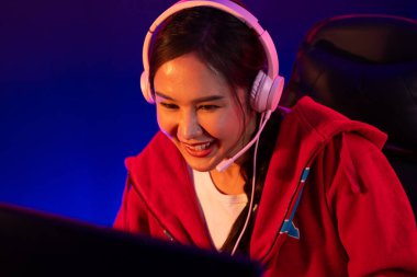 Portre sunucusu güzel Asyalı kız flamasının çevrimiçi oyun oynaması kulaklık takması pastel renkli konuşmalar izleyici medyası ile çevrimiçi. Esport yetenekli takım oyuncuları neon mavi odada. Taktik.