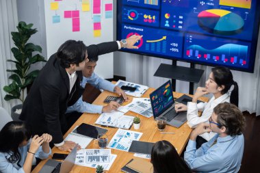 Toplantı masasındaki finansal veri raporlarını analiz eden çeşitli iş analist gruplarının geniş görüşü. İş zekası analizine göre çizelge ve grafik paneli. Çok titiz.