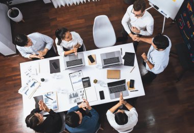 Üst düzey ofis çalışanları stratejik iş pazarlama toplantısı üzerine anlaşma yaptıktan sonra el sıkışıyor. Takım çalışması ve olumlu tutum verimli ve destekleyici bir iş yeri yaratır. Tedbirli