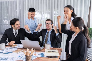 Kutlama jesti ve başarılı takım çalışması yapan bir grup mutlu iş adamı. Çeşitli yarış bürosu çalışanları şirket ofisinde pazarlama planlamasında ilerleme kaydettikten sonra kutlama yapıyorlar. Çok titiz.