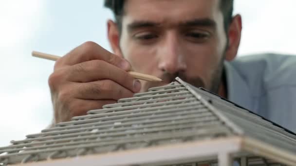 专业的建筑师工程师在现代化的写字楼里用铅笔测量模型屋顶的长度 具有摩天大楼 城市景观 熟练的项目经理或商人检查房屋的建造 小道消息 — 图库视频影像