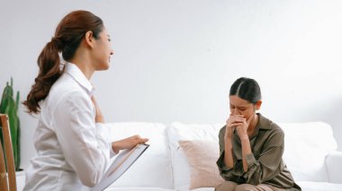 Psikologla ruh sağlığı terapisi gören üzgün travma sonrası stres bozukluğu olan bir kadın. Yaşam sonrası depresyon veya keder. Hayal kırıklığına uğramış genç bir kadın klinikteki duygular hakkında Vivancy psikoloğuyla konuşuyor.