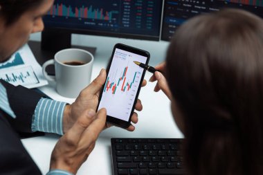 Telefona odaklanmak ve modern ofisteki gerçek zamanlı döviz kuru risk verileri üzerine ekranlarda dinamik borsa görüşmeleri yapmak. Varsayım.