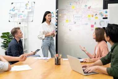 Genç ve güzel lider pazarlama stratejisini sunarken, uzman yatırımcı ve proje yöneticisi de yeni başlayan iş toplantısında iş performansını analiz etmeye çalışıyor. Çok ırklı bir grup. Tertemiz..