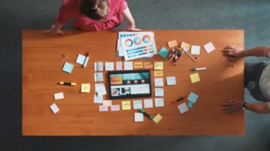 Web tasarımı için birlikte çalışan iş adamlarının üst düzey görüşü. Tasarımcı beyin fırtınası yapan ve web sitesi arayüzü hakkında tartışan ve dijital tasarım ile tablete bakan hava görüşü. Sempozyum.