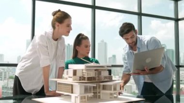 Akıllı mimar takımı ev tasarımı hakkında tartışırken yakışıklı erkek işçi dizüstü bilgisayar kullanarak fikir sunuyor. Profesyonel mühendis paylaşımı, beyin fırtınası tasarımı. İş tasarımı. İzleme