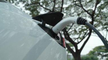 EV elektrikli araç EV şarj istasyonu ulusal park veya açık hava orman manzaralı. Çevre dostu EV arabalarla yaz ormanlarında doğal koruma. Yükselt