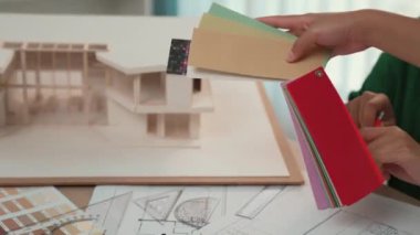 Mimari ekipman kullanan yavaş hareket eden iç mimar bir plan çizerken, iç mimari tasarımcı da müşterilerin talebine göre uygun renk ve malzeme seçiyor. Değiştirilmiş