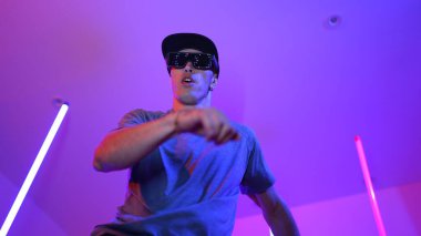 Beyaz dansçının gösterişli gözlükler taktığı ve break dans yaptığı alçak açılı kamera. Çekici adam kendinden emin bir şekilde kameraya bakarken enerjik bir performans ve hareket gösterdi. Mutluluk.