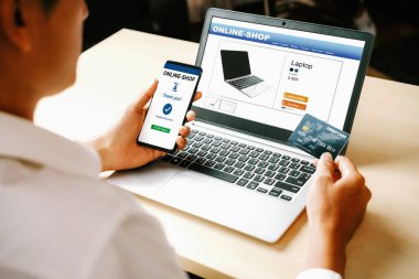 Genç adam, laptop bilgisayar başvurusu ya da web sitesinde online alışveriş yapmak için kredi kartı kullanıyor. E-ticaret ve online alışveriş konsepti. uds