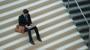 Üst düzey bir iş adamı merdivenlerde otururken başarılı bir projeyi kutluyor. Proje yöneticisi yeni bir pozisyon alıyor, terfi alıyor, arkadaşlarını ararken dizüstü bilgisayar kullanarak satışları artıyor. Sevinçli..