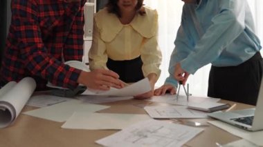 Mimarlık ve güvenlik mühendisi, modern ofiste dizüstü bilgisayarda mimari belge ve ahşap blokla sergilenen planlar hakkında tartıştı. - Yakın çekim. Tanımlama.