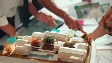 Akıllı iş adamlarının tasarımı planlamak için tabletten proje planına bakarken ve planlar ve toplantı masasındaki bina inşaatı hakkında tartışırken birlikte çalışması. Hizalama.