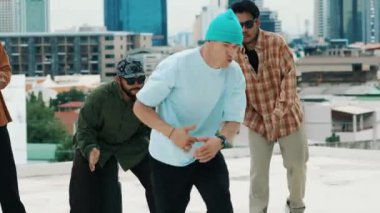 Çatıda çok kültürlü arkadaşlar varken profesyonel İspanyol break dansçısı B boy dansı. Genç modern dans grubu hip hop hareketi yapıyor. Tarz, moda, aksiyon. Açık hava sporu 2024 hiphop..