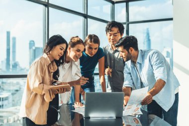 Asyalı proje yöneticisi, profesyonel iş adamları iş toplantısında pazarlama fikrini araştırırken dizüstü bilgisayarda gösterilen veri analizini kullanır. Birlikte çalışmak, fikir paylaşmak, planlama stratejisi. İzleme.